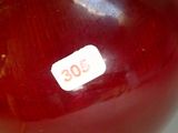 a close up of a red vase with a sticker on it