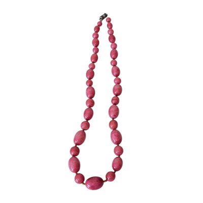 a close up of a pink necklace on a white background