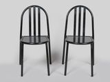 deux chaises noires placées l'une à côté de l'autre sur une surface blanche