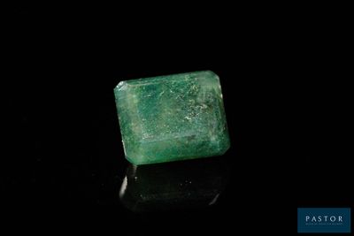 un gros plan d'une émeraude verte sur une surface noire