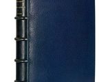 a blue leather bound book with three books on it