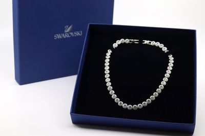 un collier de perles blanches dans un coffret cadeau bleu