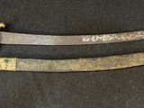 pair of old and rusty swords on a black surface