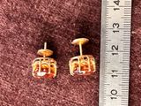 a pair of earrings that are sitting on a ruler