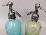 pair of green and blue glass soap dispensers on a white background