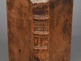 un vieux livre posé sur une table à côté d'un fond gris