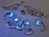 a blue glow in the middle of a pair of brooches