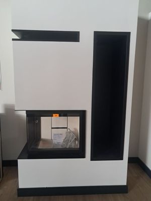 une cheminée noire et blanche dans une pièce avec du parquet