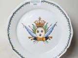 une assiette sur laquelle est représentée une couronne et deux épées