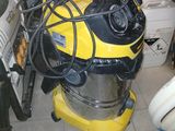 un aspirateur jaune et noir posé sur un sol carrelé