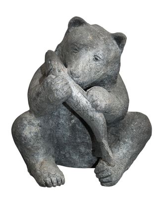 a statue of a bear that is sitting on a rock