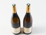 two bottles of wine sitting next to each other on a white surface