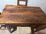 a wooden table with two chairs next to it