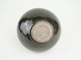 a close up of a black and white bowl on a white surface