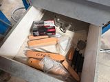 a man that is opening a drawer with tools in it