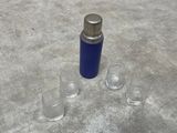 a blue bottle and two glasses on the floor