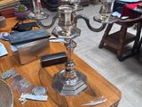 a table with a silver plate and a silver candelabra on it