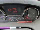 a car dashboard with a speedometer and a pen next to it