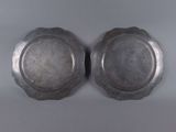 a pair of silver plate with a flower design on each side