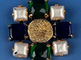 an image of a brooch with pearls and a gold coin on a blue background