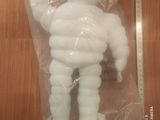 une peluche blanche dans un sac en plastique posé sur une table