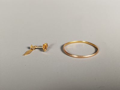 un gros plan d'une bague en or et d'une bague en or posée sur une surface blanche