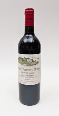 une bouteille de vin rouge posée sur une table blanche