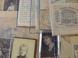 a lot of old photos and letters on a table