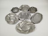 a lot of silver dishes on a white table