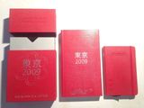 trois livres rouges posés les uns à côté des autres sur une table