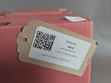 a pink suitcase with a qr code attached to it