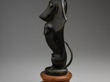 a statue of a dog sitting on top of a wooden base