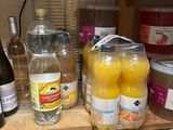 many bottles of wine and bottles of orange juice on a shelf
