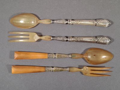 four spoons and a fork are lined up on a table