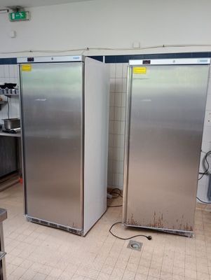 two stainless steel refrigerators in the middle of a kitchen