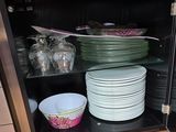 many plates and bowls in a cabinet with a glass door