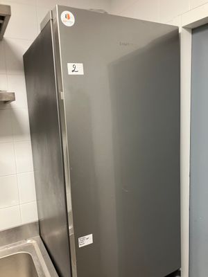 a stainless steel refrigerator in a kitchen next to a sink