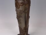 a brown vase with a handle on a white table