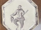 a plate with a drawing of a man holding a sword and shield