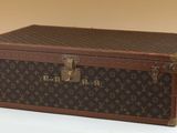 a brown and black suitcase sitting on a white surface