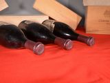 several bottles of wine are lined up on a red table