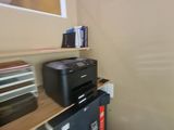 a black printer sitting on top of a black refrigerator