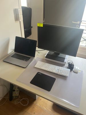 un bureau sur lequel sont posés deux ordinateurs et un ordinateur portable