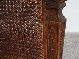 a wooden chair that has a wicker seat on it