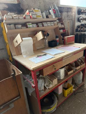 un établi dans un garage, sur lequel sont posés de nombreux outils