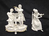 deux figurines blanches représentant des femmes jouant de la musique, posées sur une table