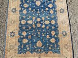 a blue and beige rug with a floral design on it