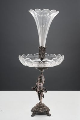 un plateau en argent sur lequel est posé un vase en verre