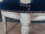 a close up of a chair with a blue velvet seat