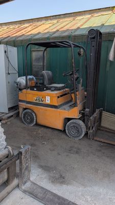 un chariot élévateur à fourche garé devant un bâtiment